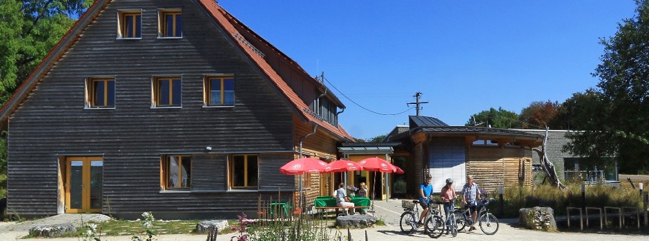 Naturschutzzentrum Schopflocher Alb, davor Ausflügler mit Fahrrädern